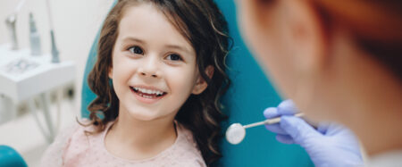 A young girl (pediatric patient) visits the dentist for a checkup.